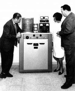 Els doctors Lluís Vallmitjana (a l'esquerra) i Font Alba (a la dreta) al costat d´un vaporitzador de metalls per tractar les mostres a observar amb un microscopi electrònic. Servei de microscòpia electrònica de la Universitat de Barcelona, 1964.